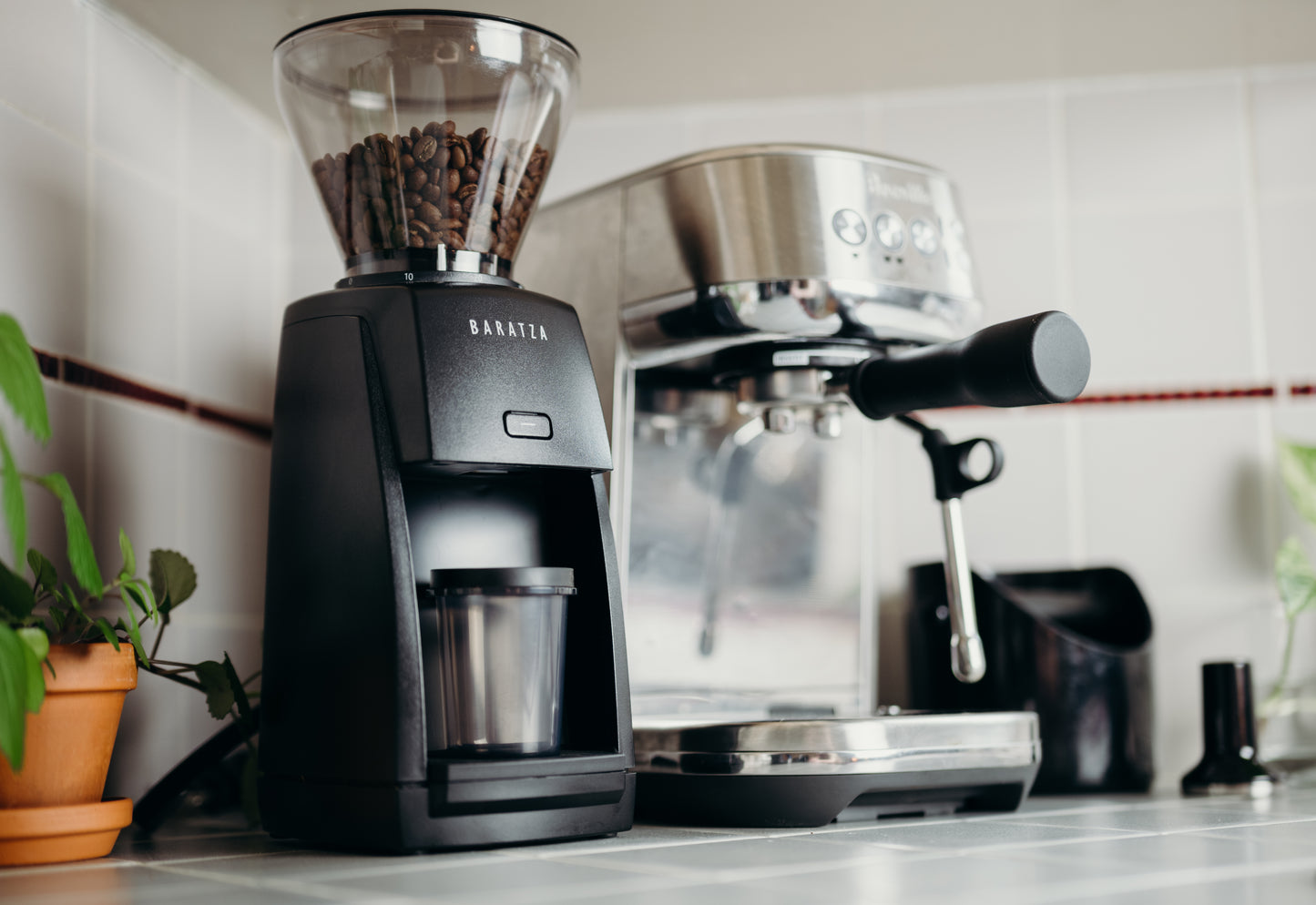 image of coffee grinder with espresso machine in background