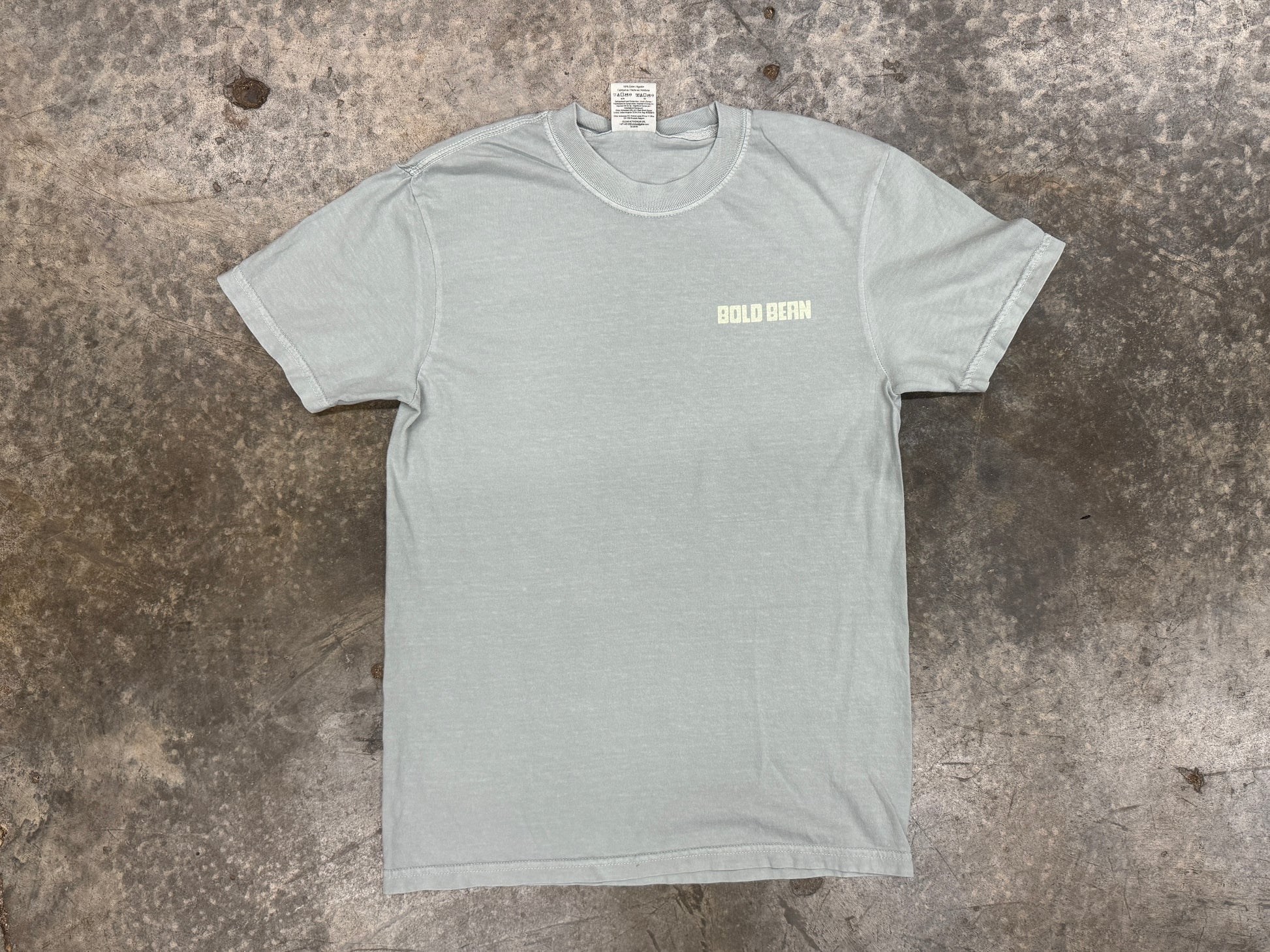 Gray t-shirt with a logo on a textured surface