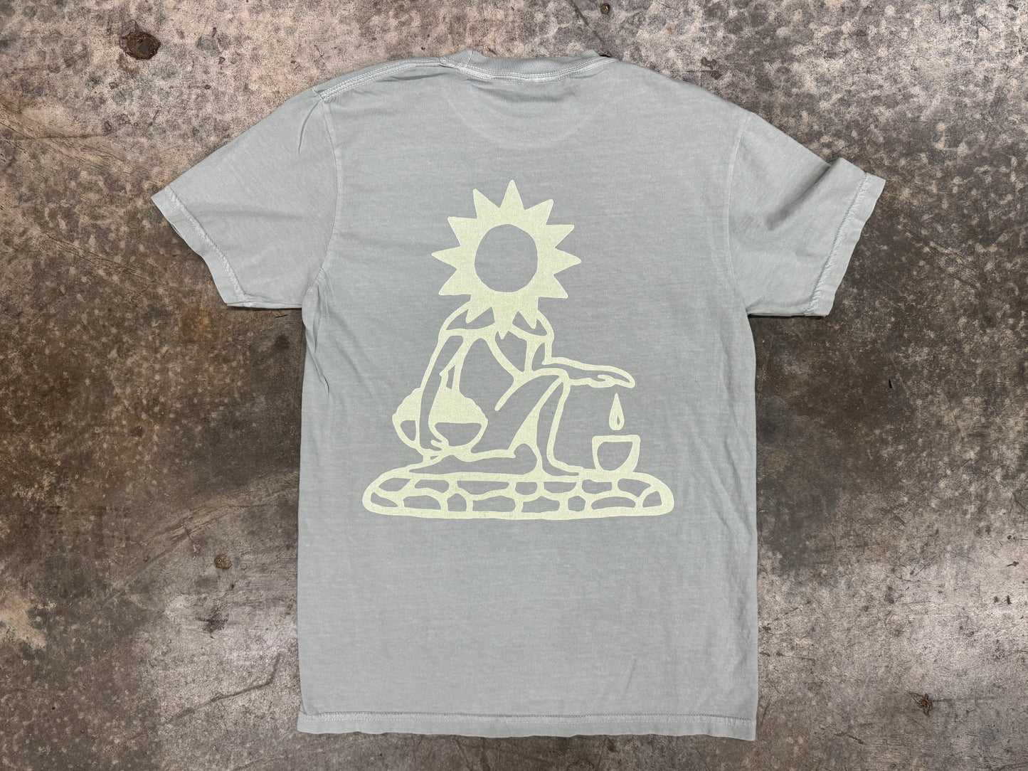 Gray t-shirt with a white graphic design on a textured surface