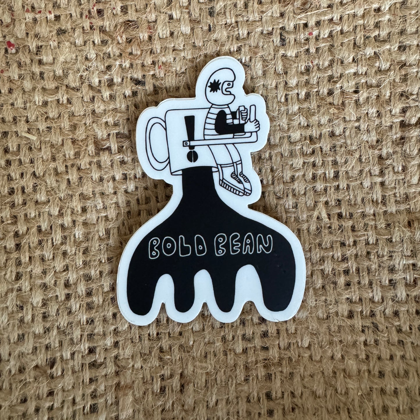 Sticker with a design of a person holding a coffee cup and the text 'Bold Bean' on a textured brown background.