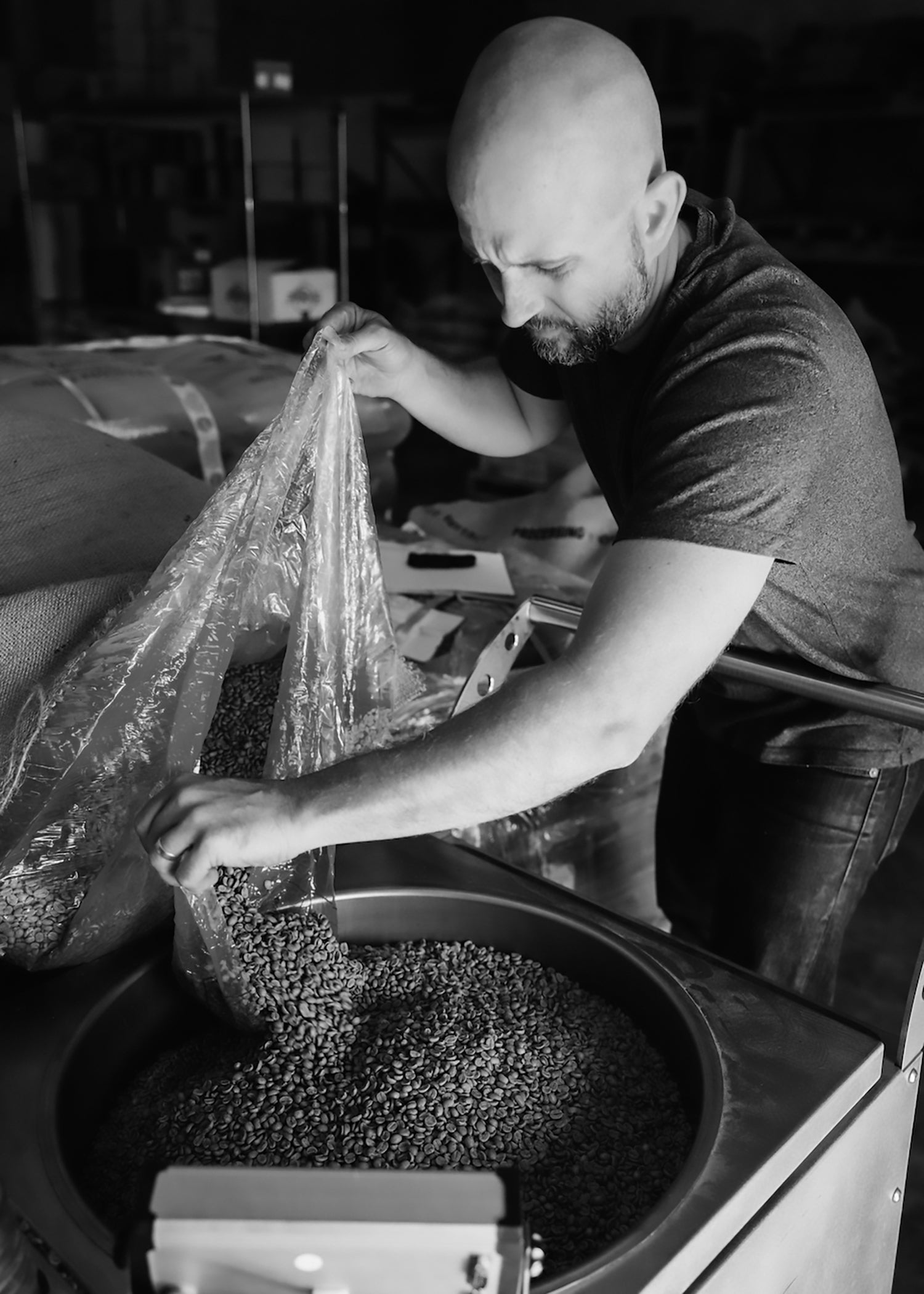image of person pouring green coffee from bulk bag into coffee bean cart