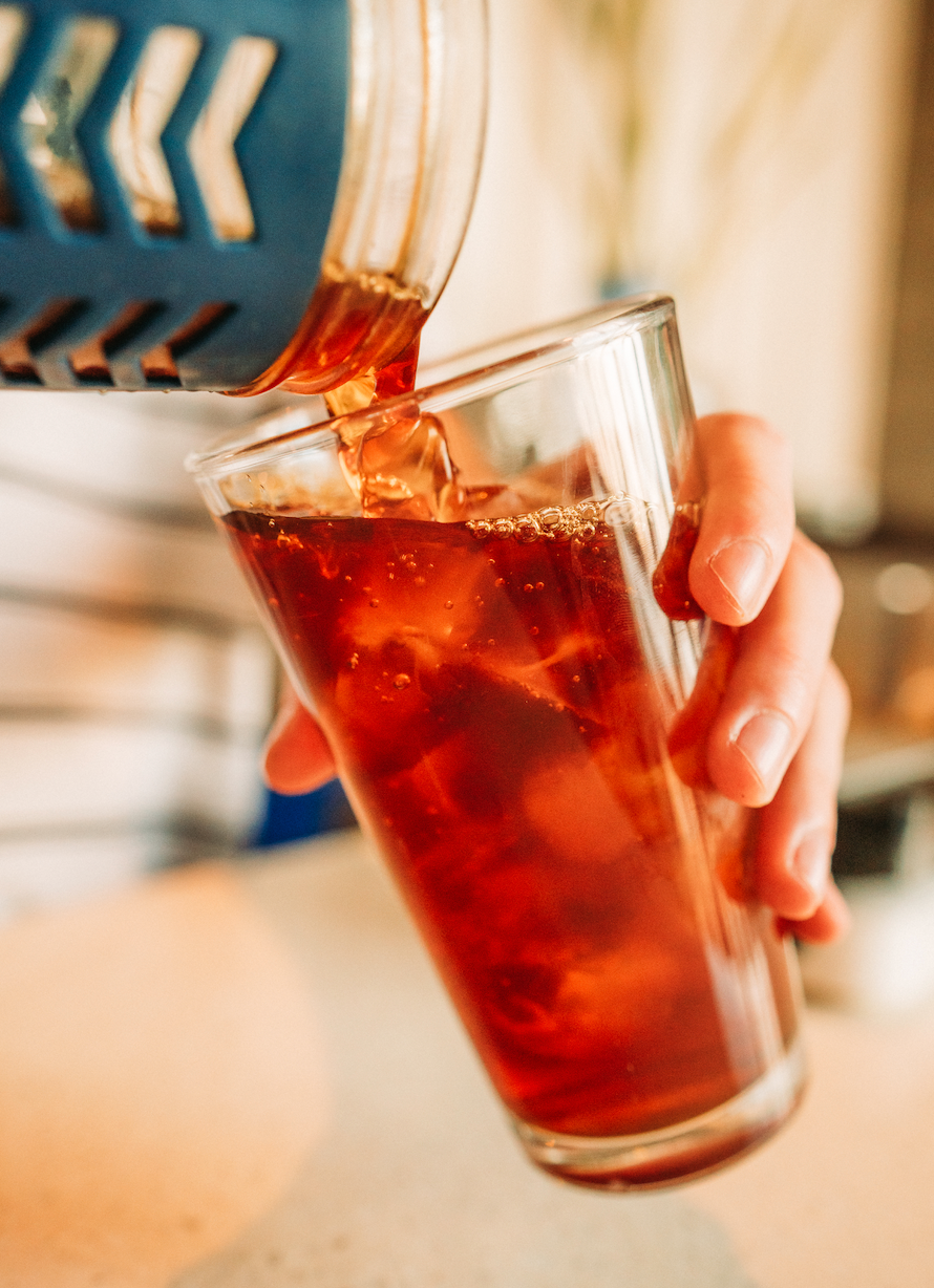 image of iced coffee being poured into glass full of ice