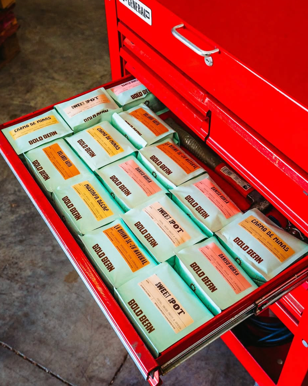 photo of assorted retail bags of coffee in a tool box drawer