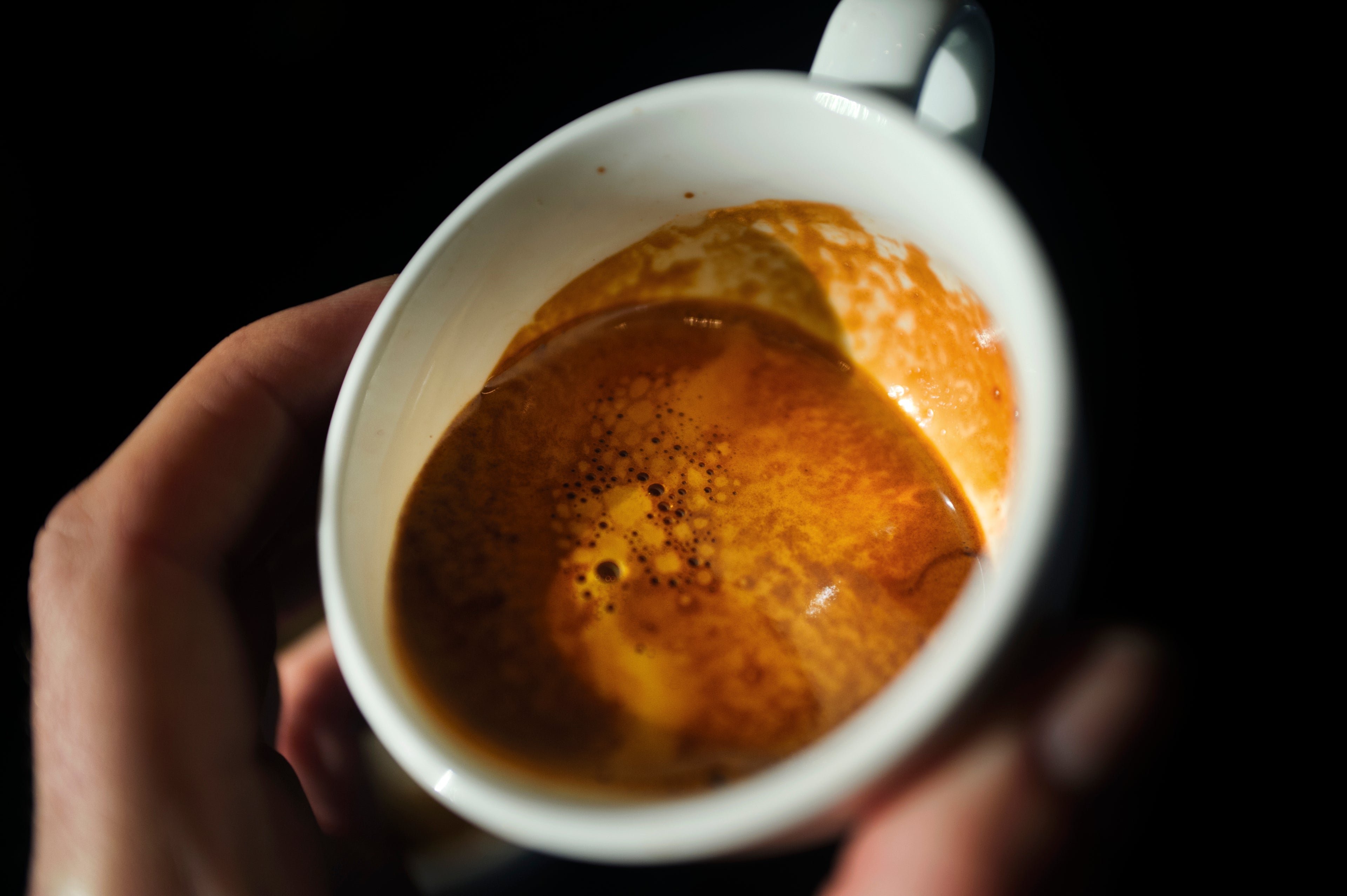 close up photo of a shot of espresso in a white ceramic demitasse cup