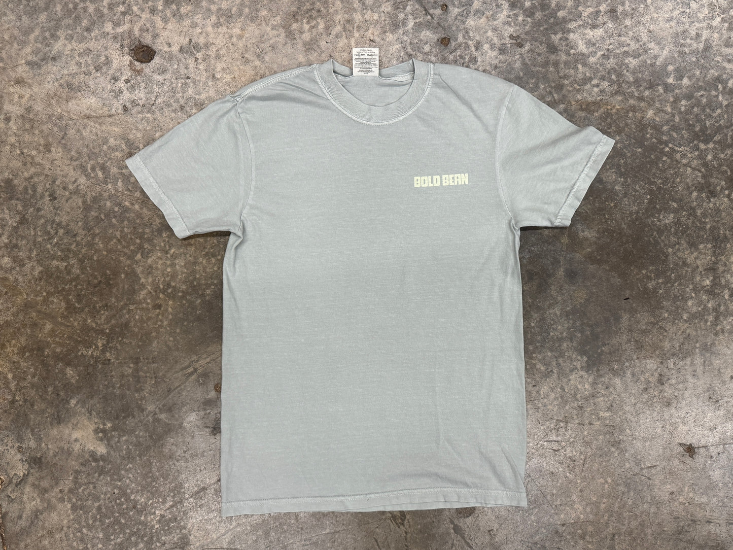 Gray t-shirt with a logo on a textured surface