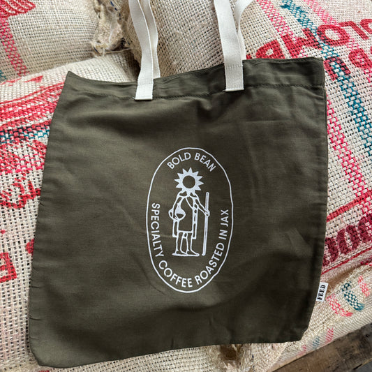 Green tote bag with a coffee roaster logo on a textured surface