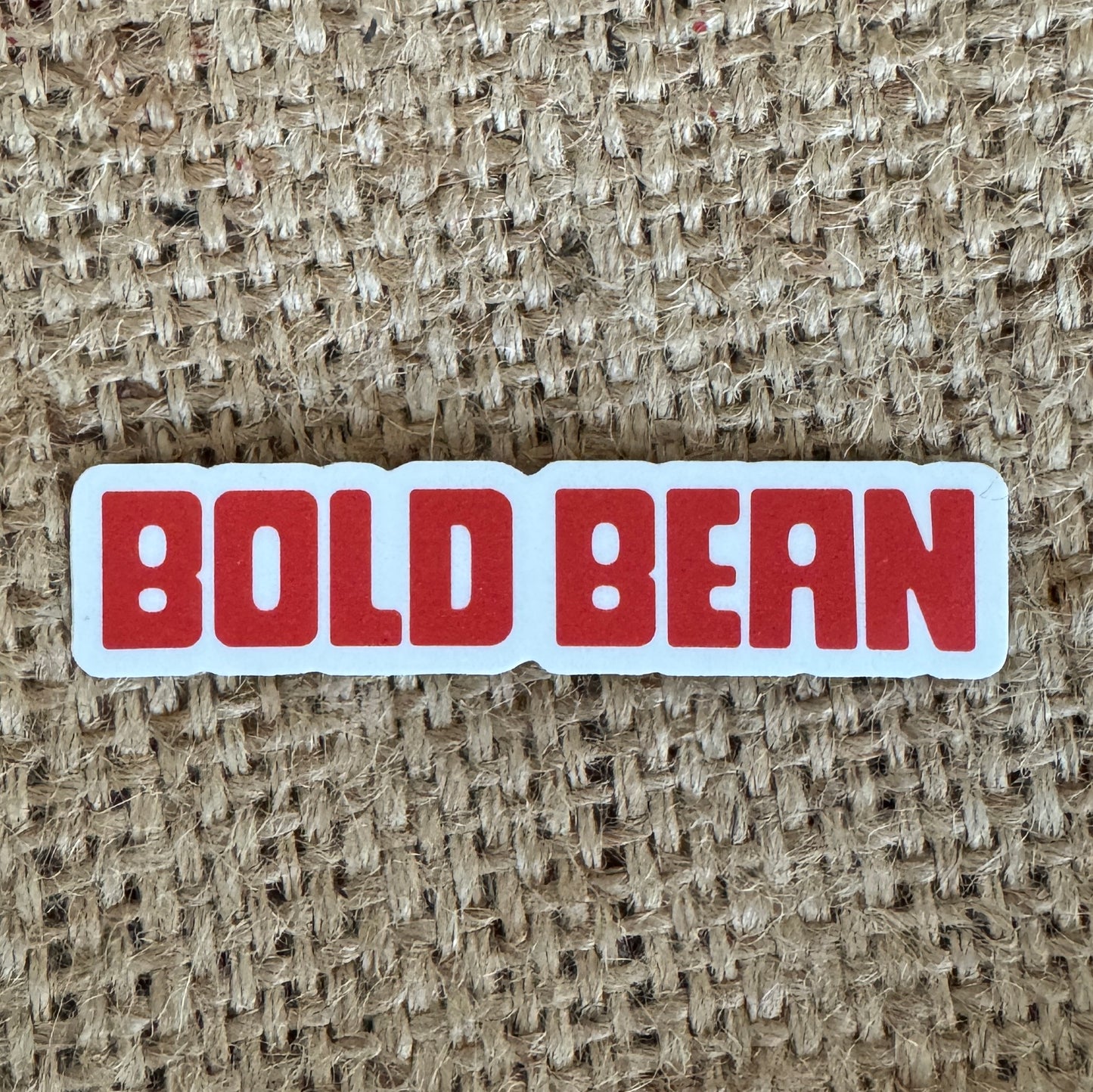 Sticker with 'BOLD BEAN' text on a textured beige background