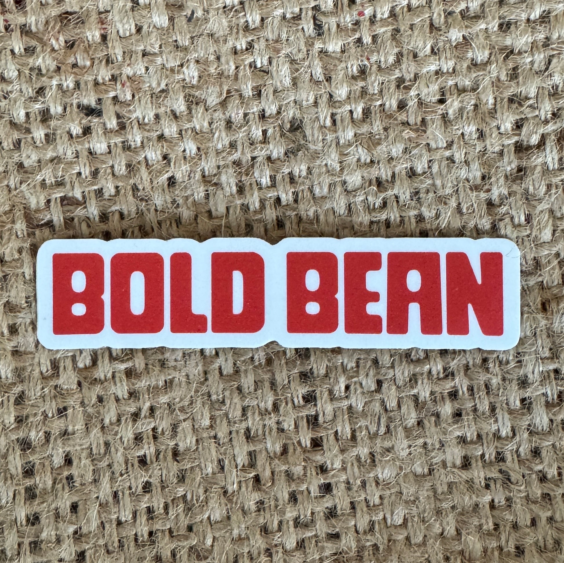 Sticker with 'BOLD BEAN' text on a textured beige background