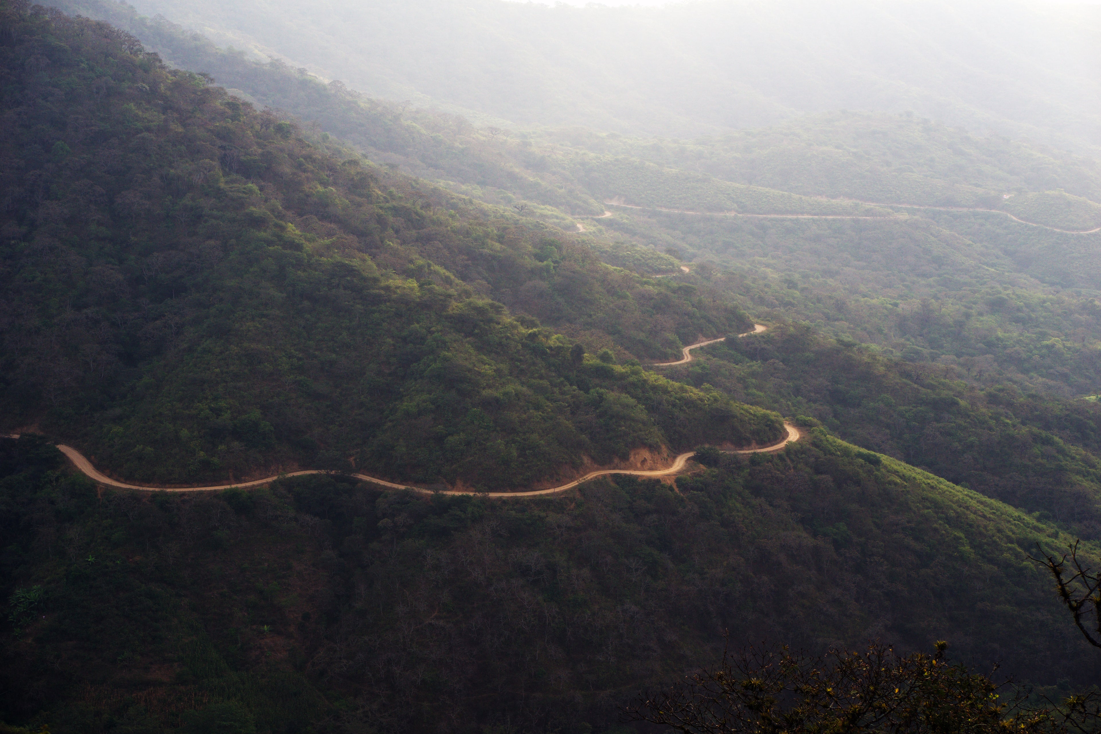 a winding dirt road through the mountains of rural Peru 