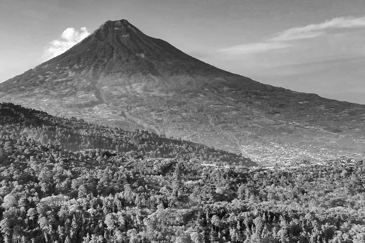 Black and white photograph of a mountain with a cityscape in the foreground