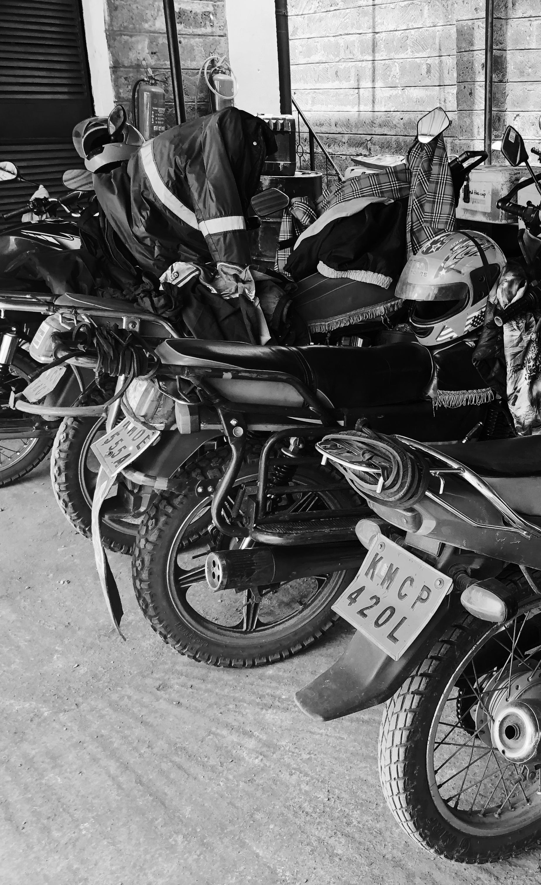 Motorcycles with helmets on top parked in a row